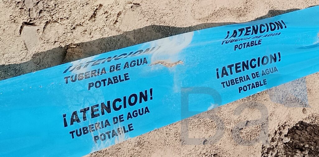 Banda de señalización en una zanja para las tuberías de abastecimiento de agua.